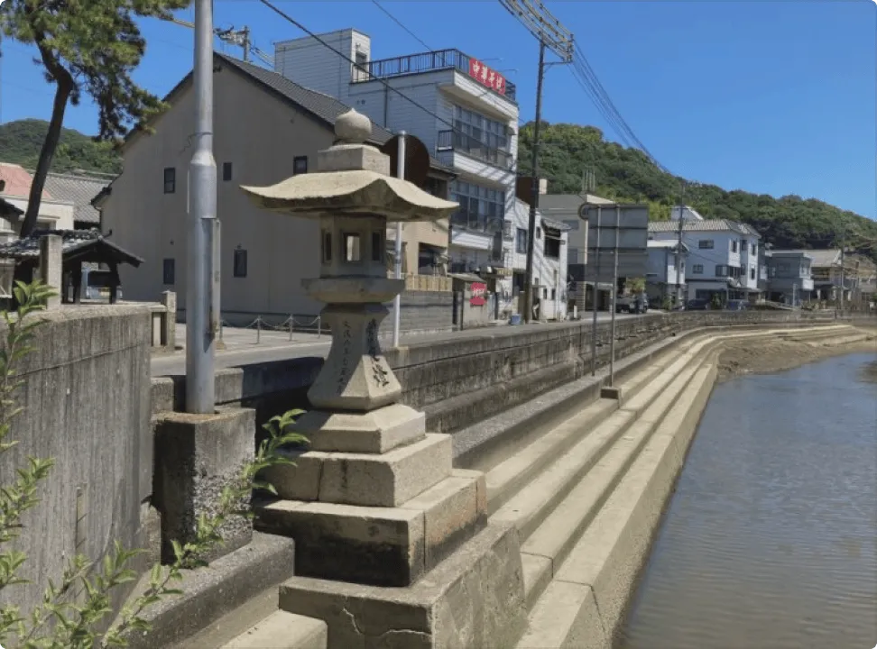 바닷가 돌계단 옆에 서 있는, 역사 깊은 석조 조야토(상시등)