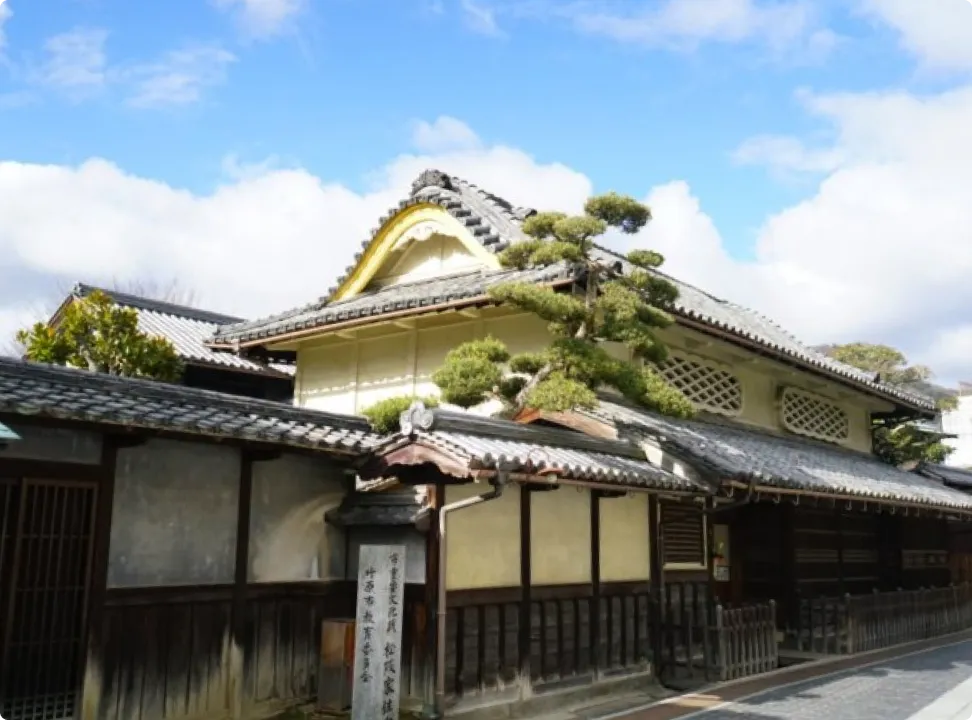 푸른 하늘 아래 자리한, 훌륭한 기와지붕을 갖춘 다케하라 거리 보존지구의 상가