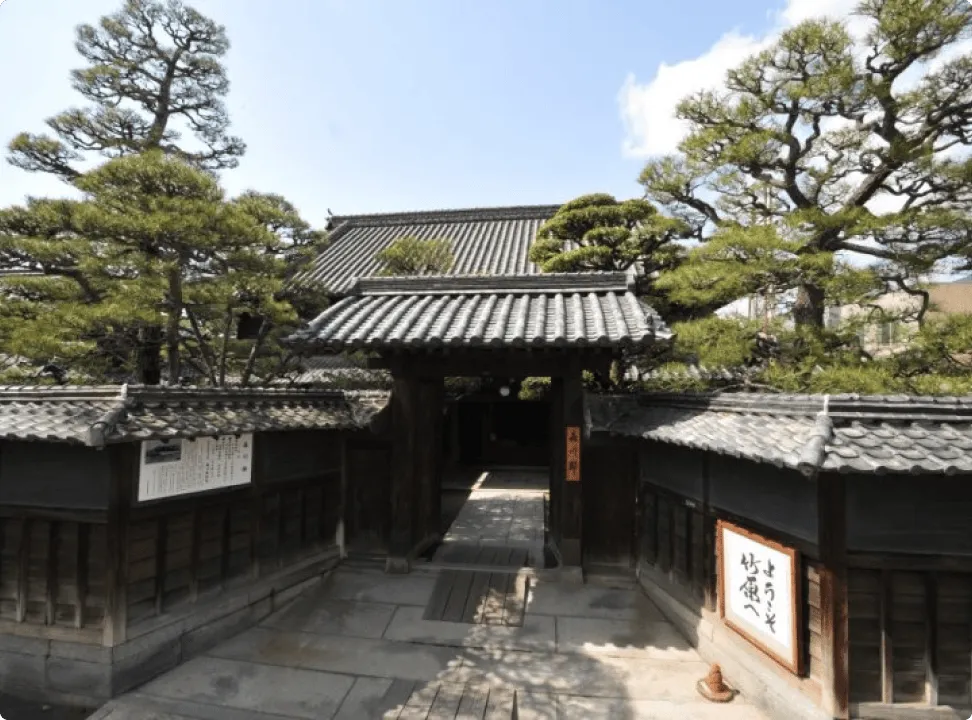 역사가 느껴지는 목조 건축의 문과 잘 손질된 정원의 나무들