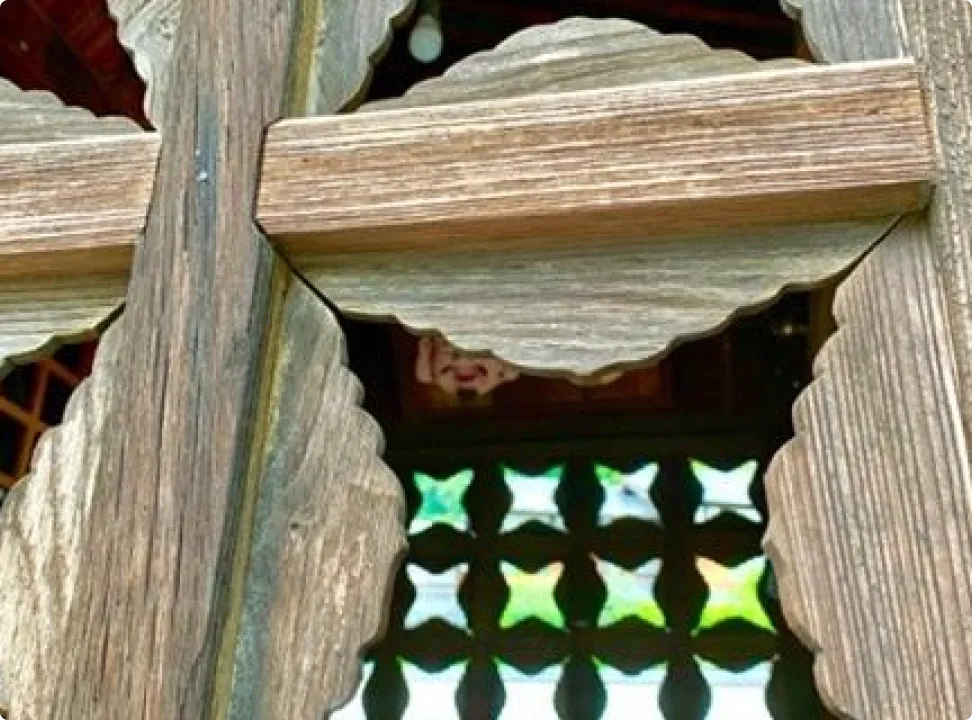 나무 격자 너머로 초록색 기하학 무늬 타일이 보이는 디자인