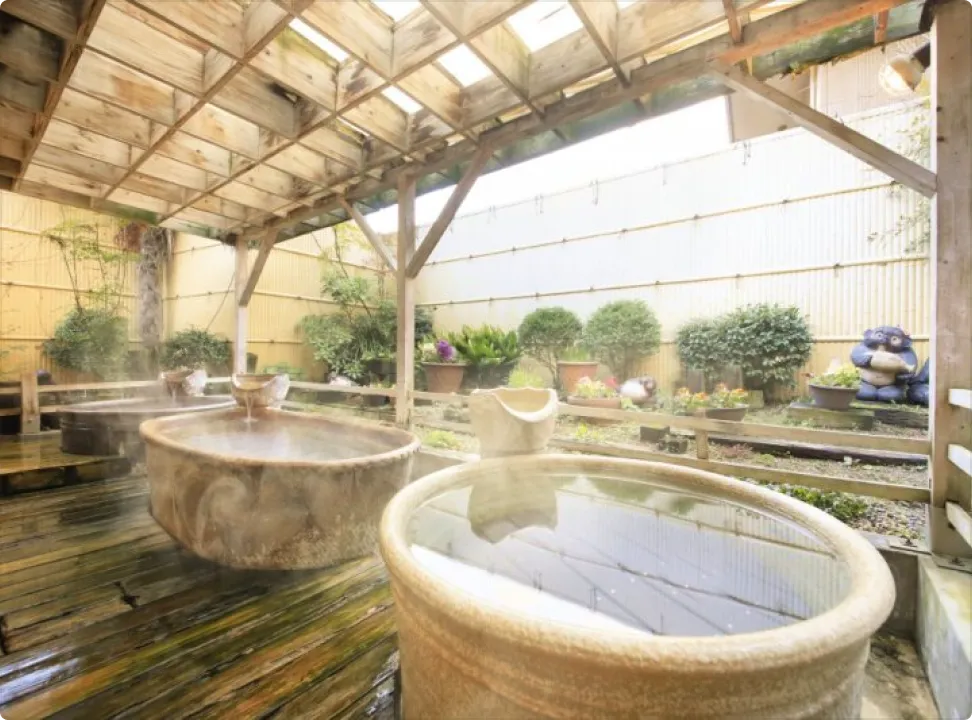 녹음에 둘러싸인 정원 안에서 분위기가 다른 여러 욕조를 즐길 수 있는 지붕이 있는 노천탕
